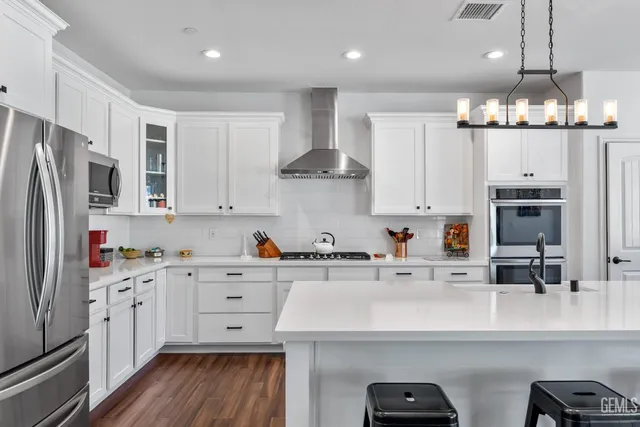 a kitchen with stainless steel appliances a sink stove refrigerator and cabinets