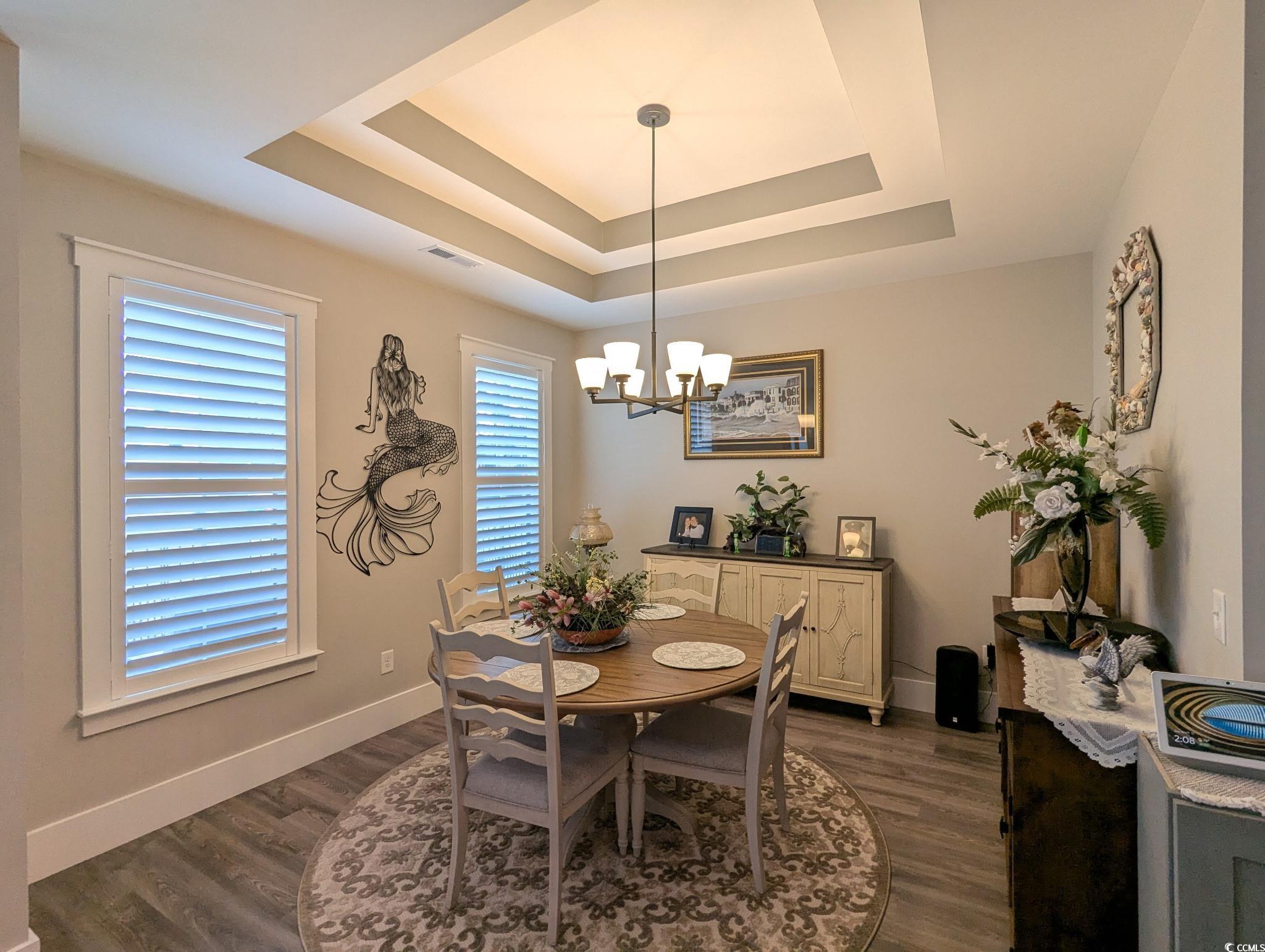 646 Pacific Commons Drive Surfside Beach, SC 29575 - Photo 12 of 40 Dining room featuring dark wood finished floors, a chandelier, and a raised ceiling