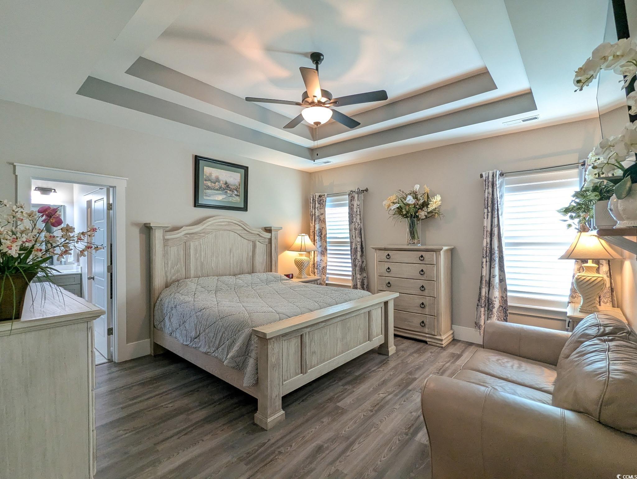 646 Pacific Commons Drive Surfside Beach, SC 29575 - Photo 13 of 40 Bedroom featuring wood finished floors, a raised ceiling, ceiling fan, and multiple windows