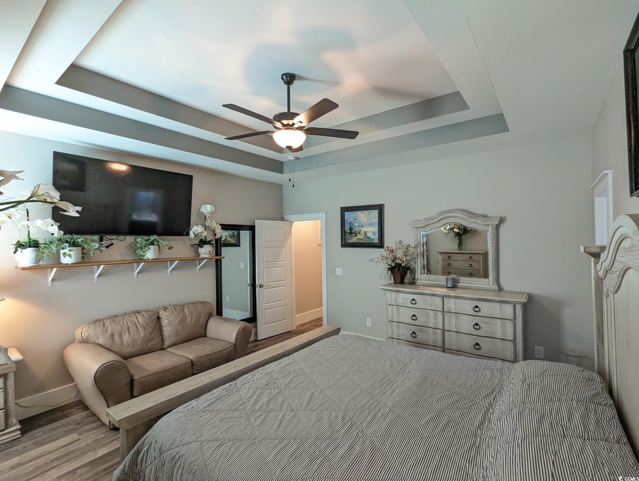 646 Pacific Commons Drive Surfside Beach, SC 29575 - Photo 15 of 40 Bedroom with a tray ceiling, a ceiling fan, and wood finished floors