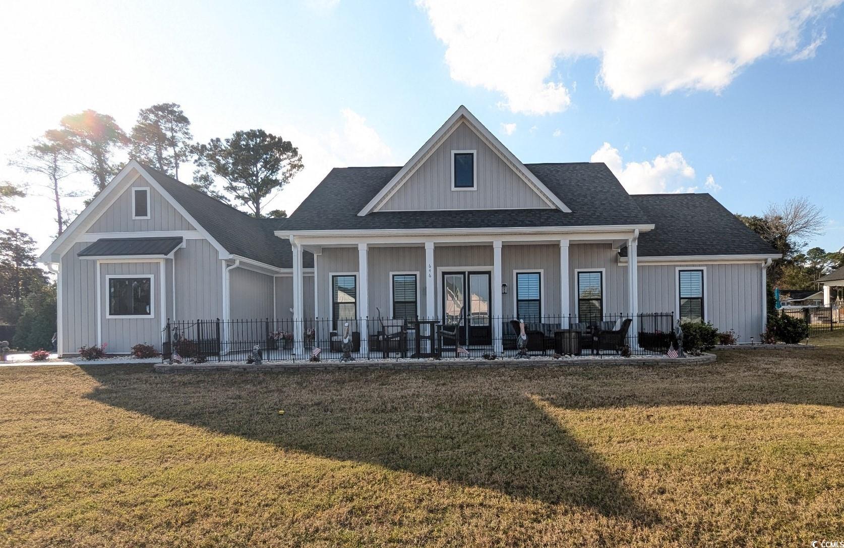 646 Pacific Commons Drive Surfside Beach, SC 29575 - Photo 2 of 40 Front view of property featuring a yard, roof with shingles, covered porch, and board and batten siding