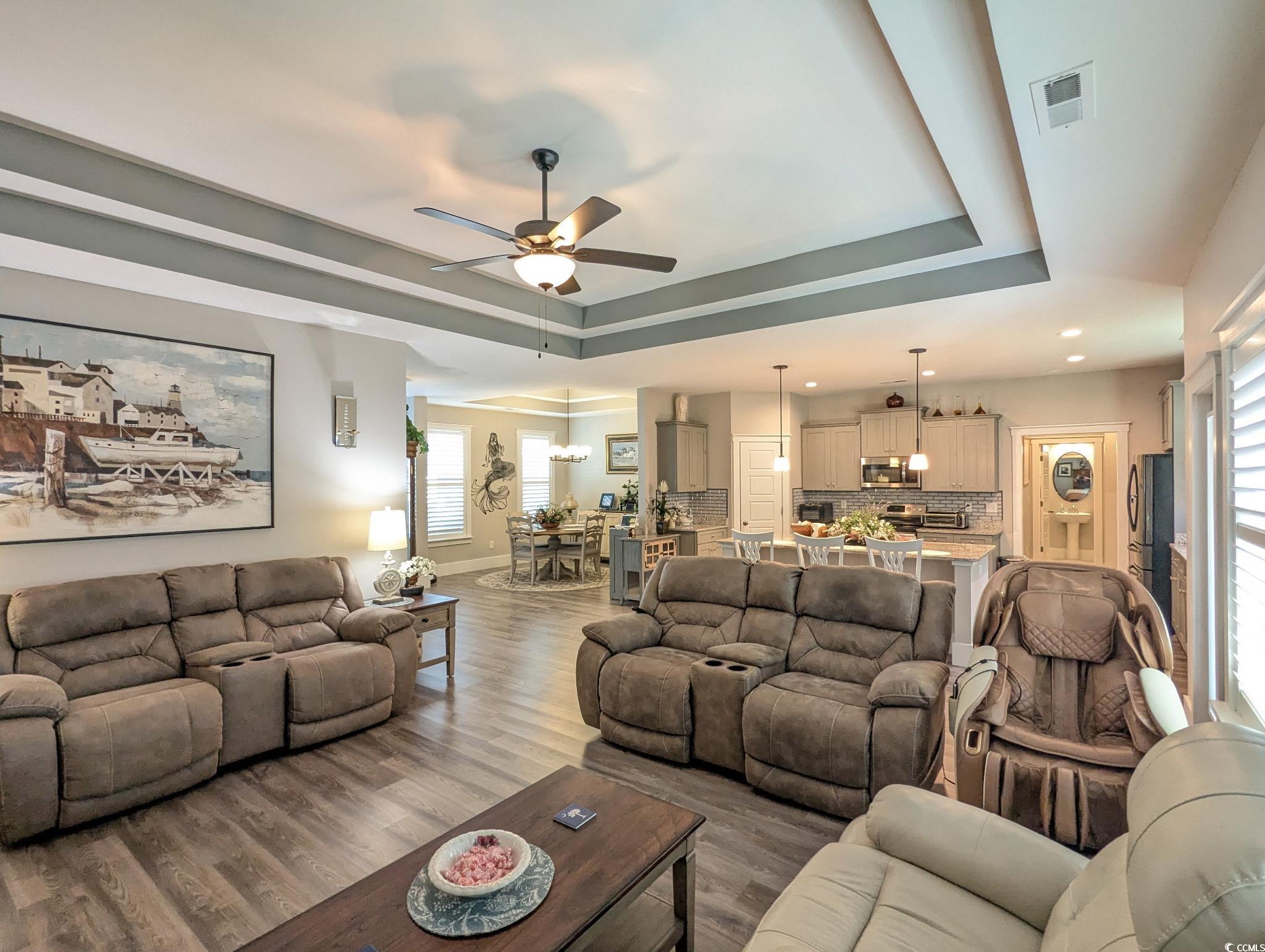 646 Pacific Commons Drive Surfside Beach, SC 29575 - Photo 7 of 40 Living area with a tray ceiling, ceiling fan, wood finished floors, and recessed lighting