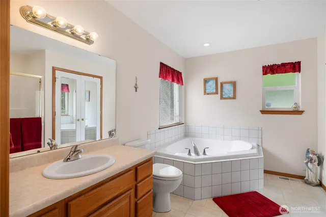a bathroom with a tub sink and mirror