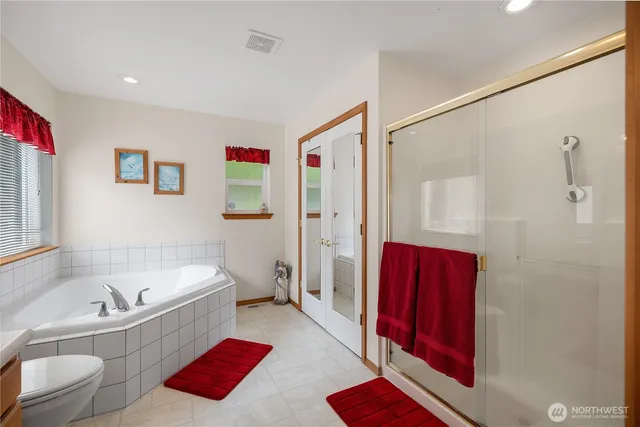 a bathroom with a tub shower sink and mirror