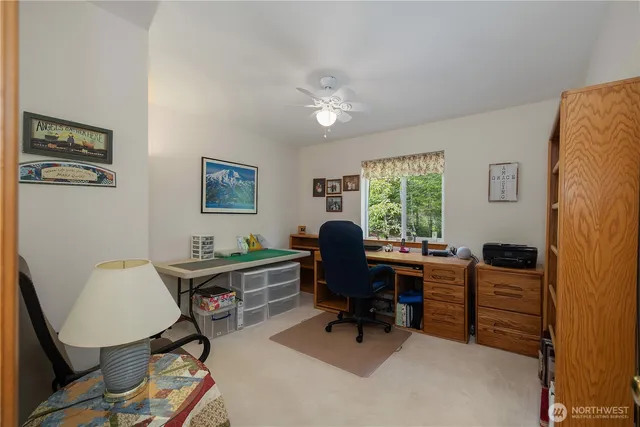 a view of a workspace with furniture and a window