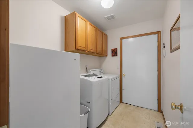 a utility room with cabinets washer and dryer