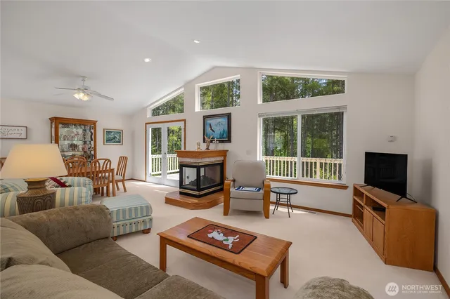 a living room with furniture a flat screen tv and a floor to ceiling window