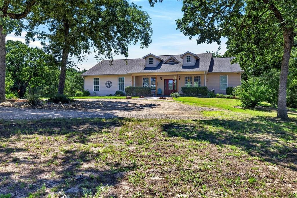 11591 Farm To Market 59 Athens, TX 75751 - Photo 1 of 40 Ranch-style residence featuring a covered front porch, multiple dormer windows, and a prominent red front door. Come sit awhile at 11595 FM 59, Athens TX 75751.