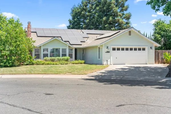 a front view of a house with a garden and garage