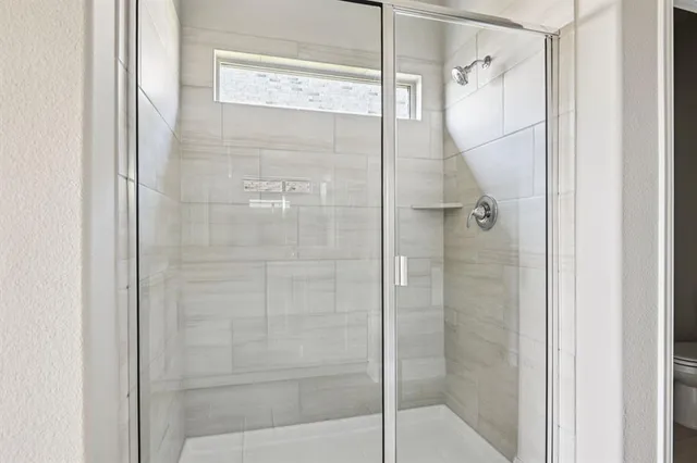 a bathroom with a glass shower door and a shower