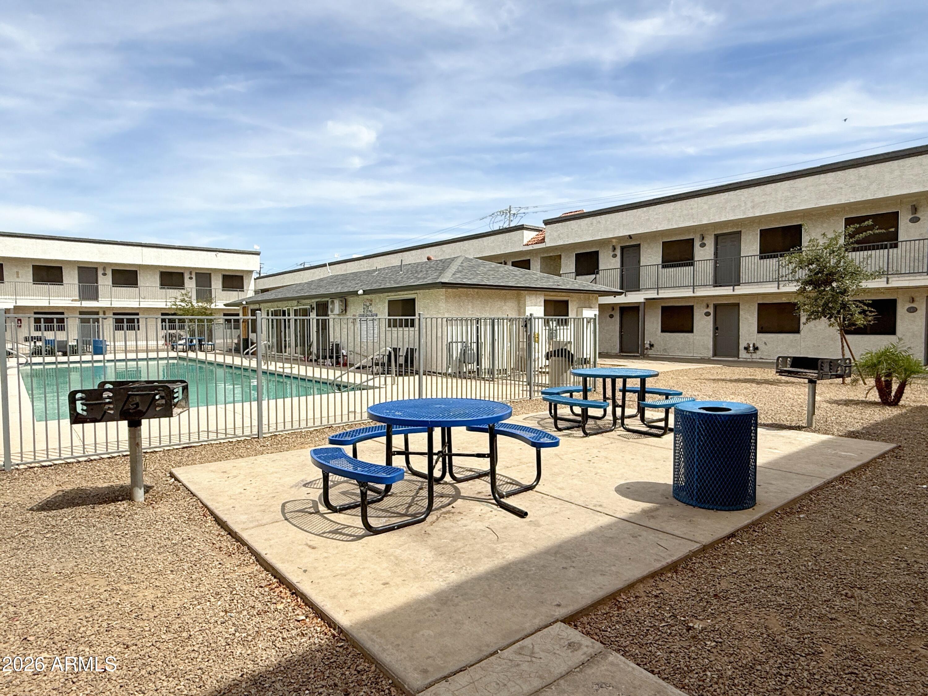 18202 North Cave Creek Road, Unit 148 Phoenix, AZ 85032 - Photo 19 of 19 a view of a patio with a dining table and chairs with wooden floor
