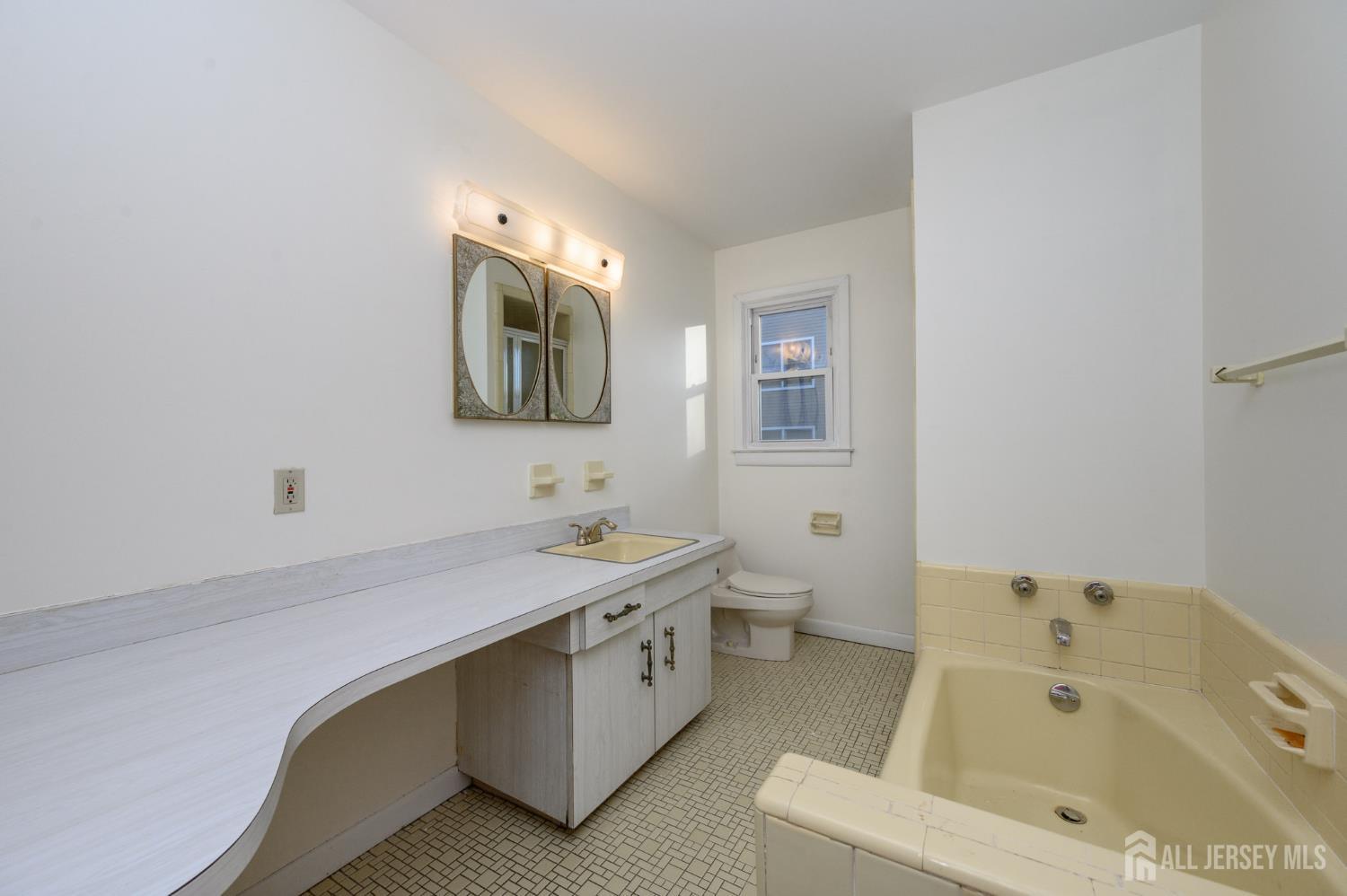 1821 Englishtown Road Old Bridge, NJ 08857 - Photo 23 of 46 a bathroom with a tub sink and mirror