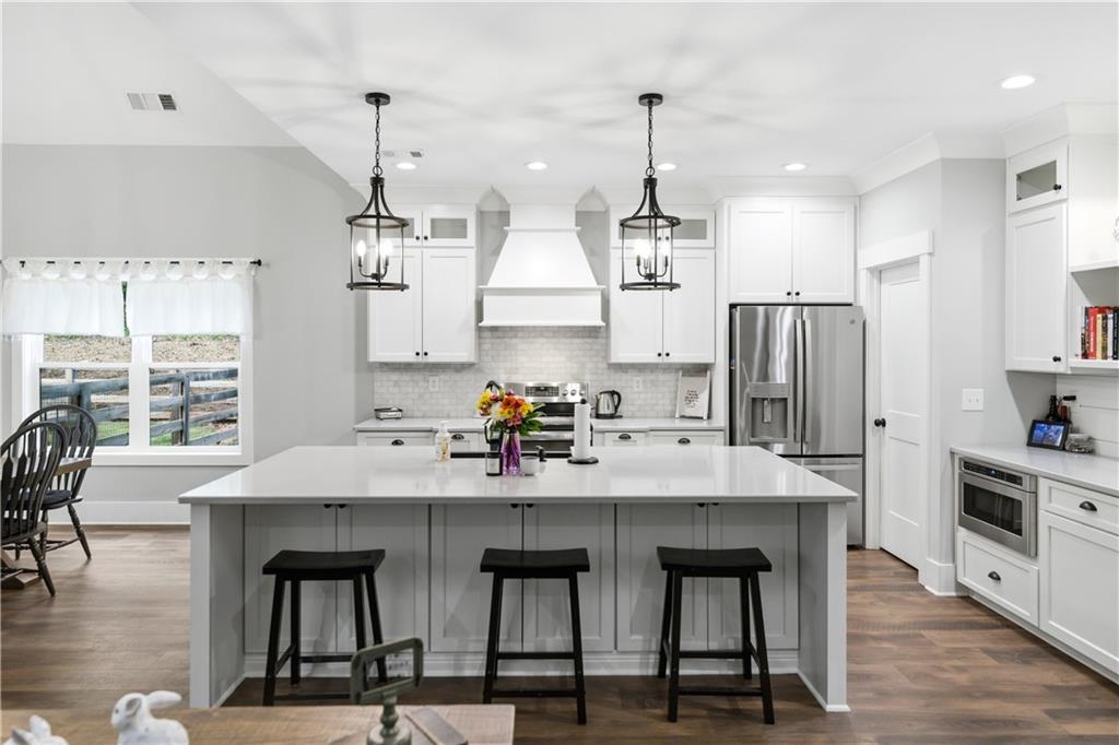 3584 Stock Road Monroe, GA 30656 - Photo 23 of 80 a kitchen with stainless steel appliances kitchen island granite countertop a table chairs refrigerator and sink
