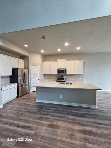 a view of kitchen with stainless steel appliances cabinets