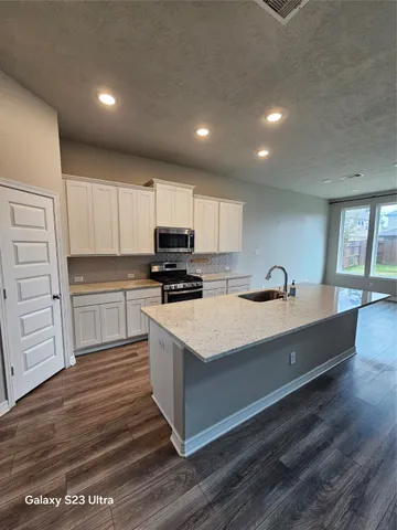 a kitchen with kitchen island sink stove and cabinets