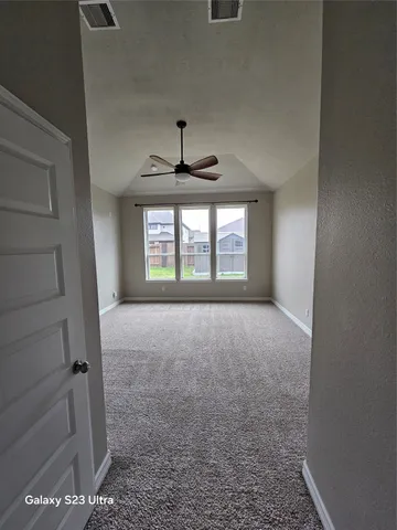 an empty room with windows and ceiling fan