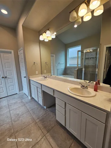 a bathroom with a glass shower door and a sink