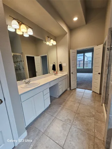 a bathroom with a double vanity sink and a mirror