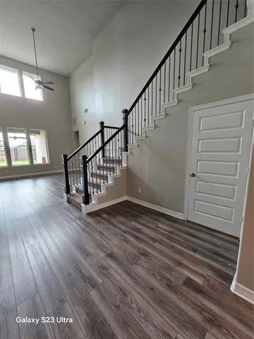 a view of staircase with wooden floor and white walls