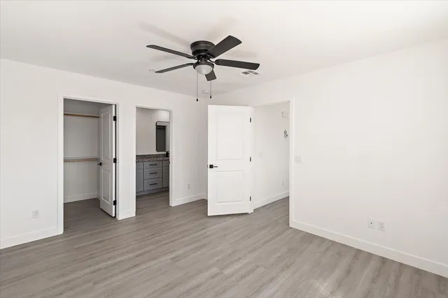 an empty room with wooden floor and entryway
