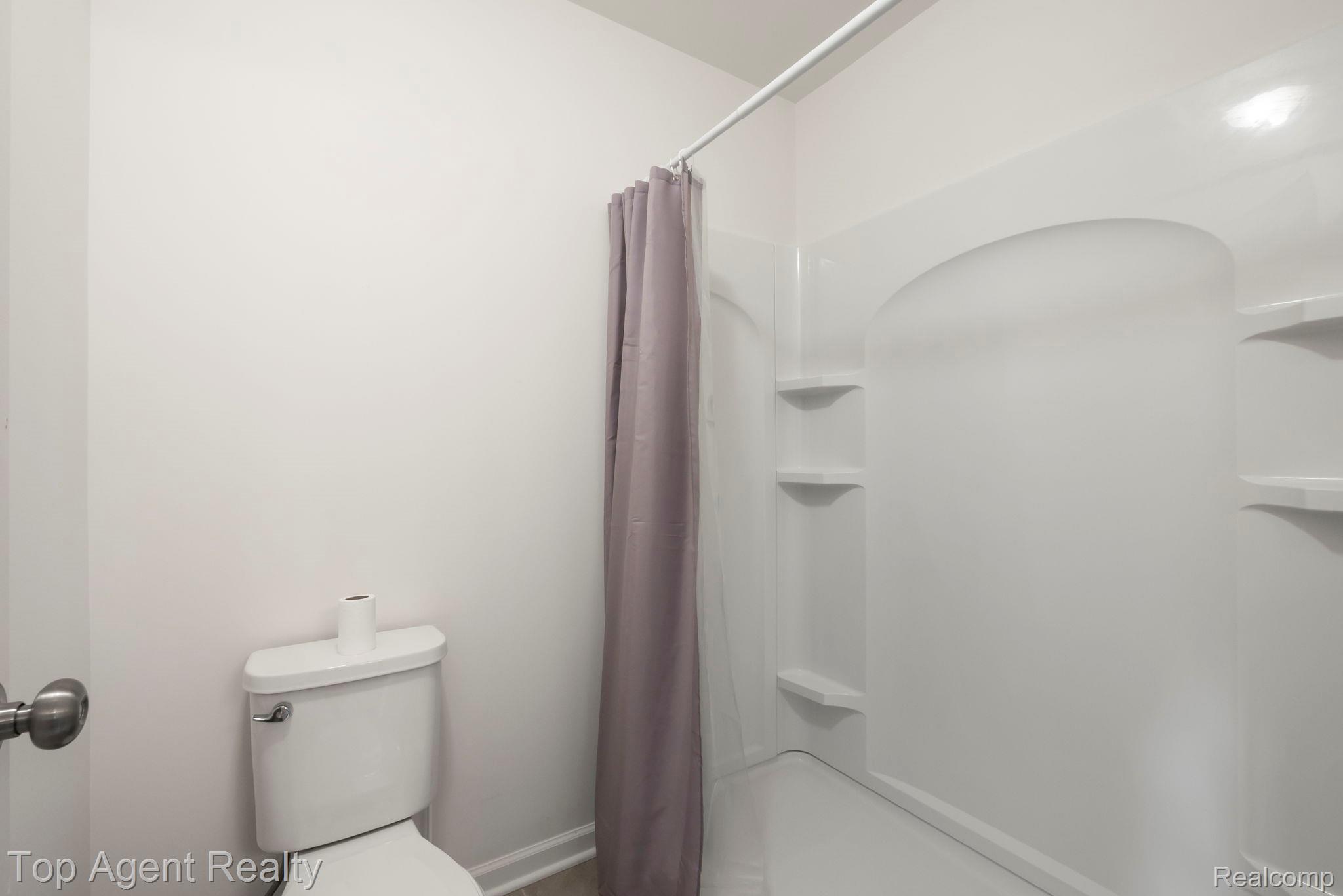 63770 Dequindre Road Washington, MI 48095 - Photo 37 of 61 White bath and shower combination with built-in shelving, a white toilet, and wood-finish flooring