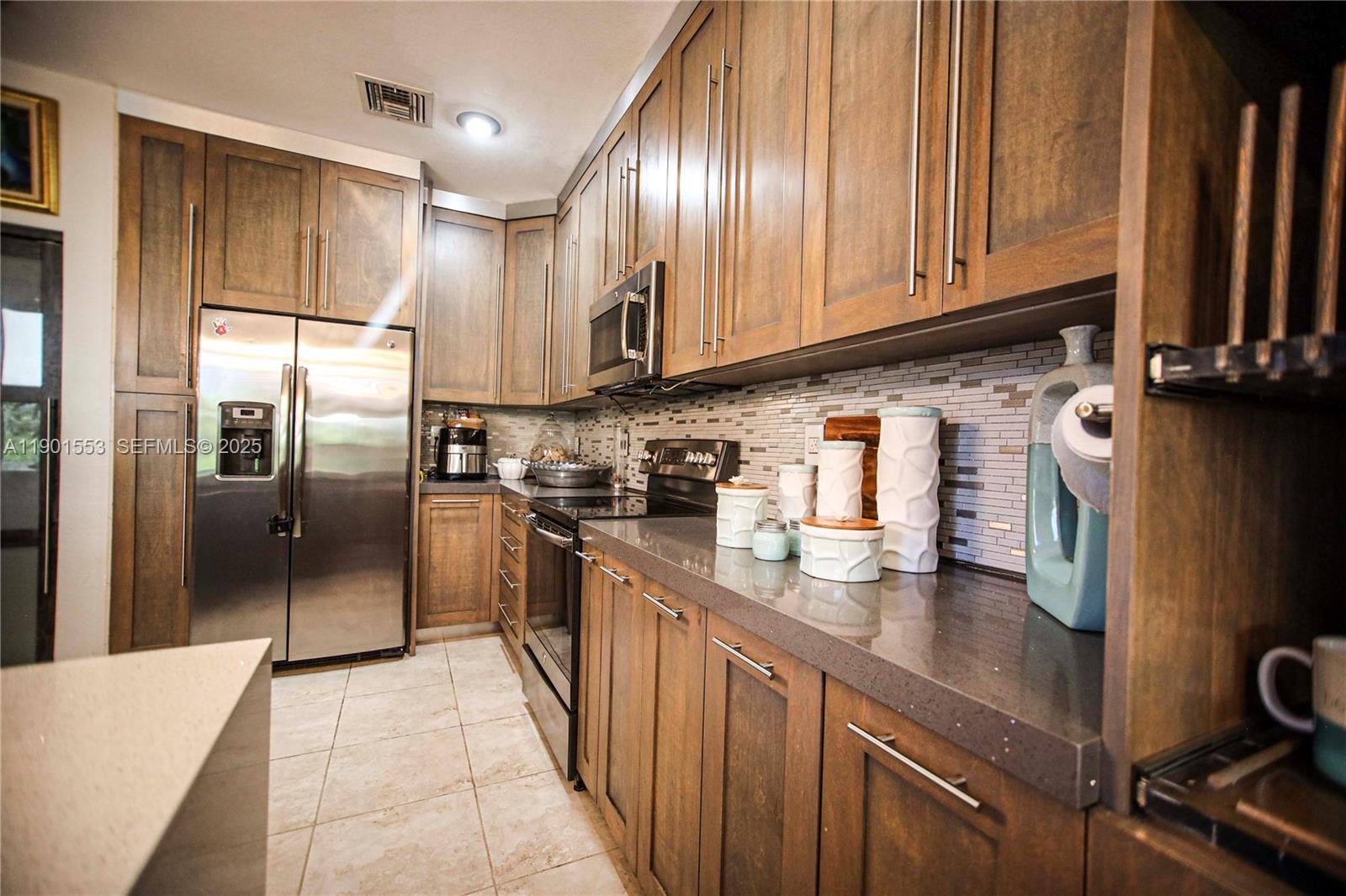 11863 Southwest 233rd Terrace Homestead, FL 33032 - Photo 22 of 77 a kitchen with stainless steel appliances granite countertop a refrigerator sink and cabinets
