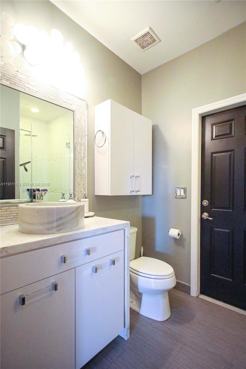 11863 Southwest 233rd Terrace Homestead, FL 33032 - Photo 39 of 77 a spacious bathroom with a toilet sink and mirror