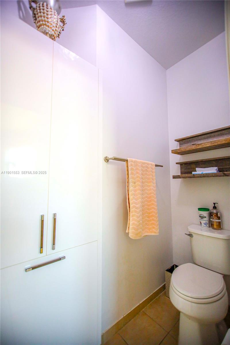 11863 Southwest 233rd Terrace Homestead, FL 33032 - Photo 52 of 77 a white toilet sitting next to a bathroom sink and vanity