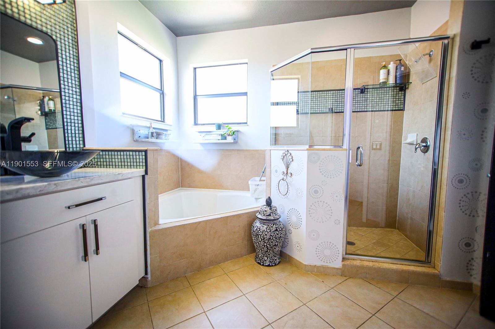 11863 Southwest 233rd Terrace Homestead, FL 33032 - Photo 53 of 77 a bathroom with a granite countertop sink a mirror and a bathtub