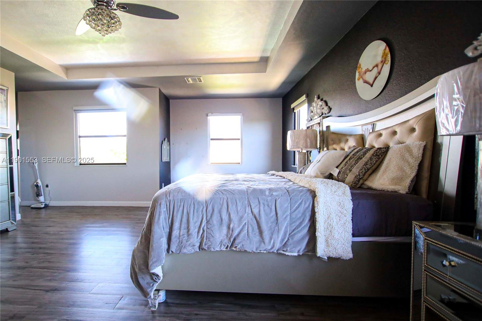 11863 Southwest 233rd Terrace Homestead, FL 33032 - Photo 66 of 77 a spacious bedroom with a bed and a chandelier