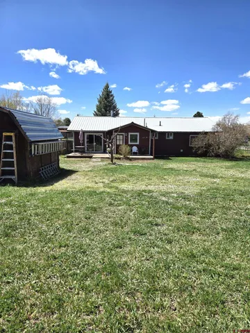a view of a house with a yard and sitting area