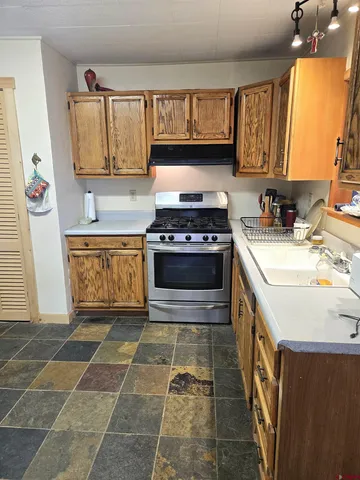 a kitchen with stainless steel appliances granite countertop a stove a sink and a microwave