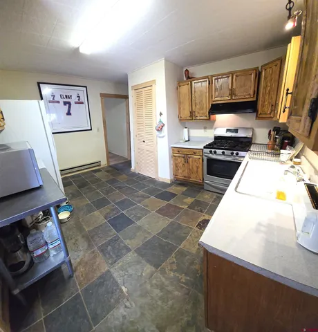 a kitchen with a stove a sink and a stove top oven
