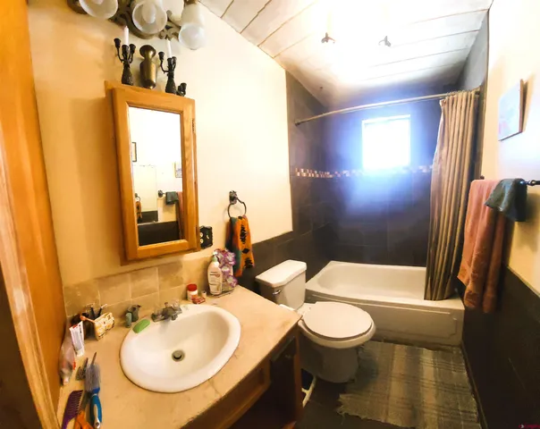 a bathroom with a granite countertop toilet sink and mirror