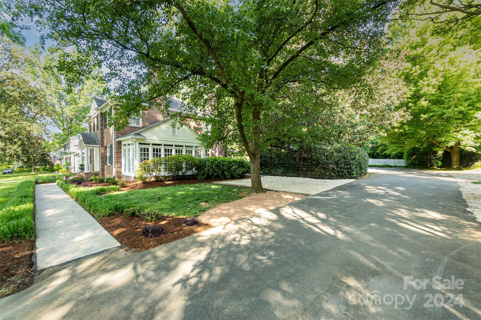 1900 South Wendover Road Charlotte, NC 28211 - Photo 32 of 38 a view of a white house next to a yard with big trees