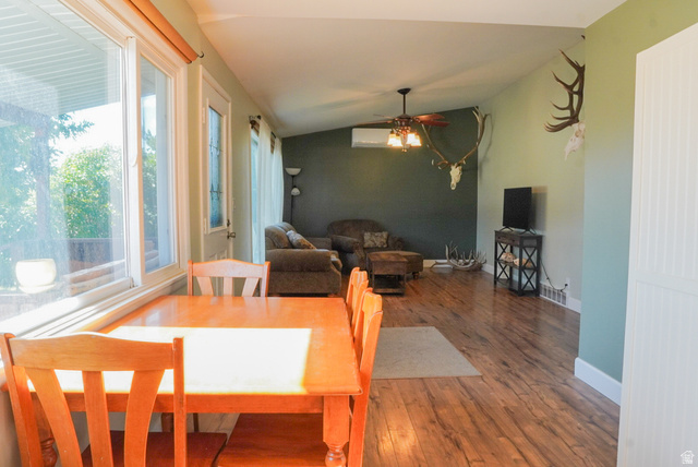 324 Stringtown Road Georgetown, ID 83239 - Photo 15 of 49 Dining area featuring lofted ceiling, wood-type flooring, a ceiling fan, and an AC wall unit