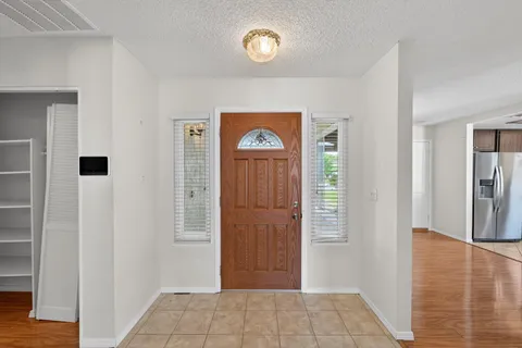 a view of a kitchen with wooden floor and an empty room