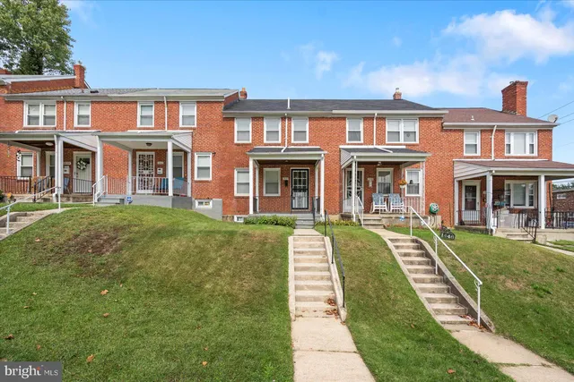 a front view of a brick building with a yard