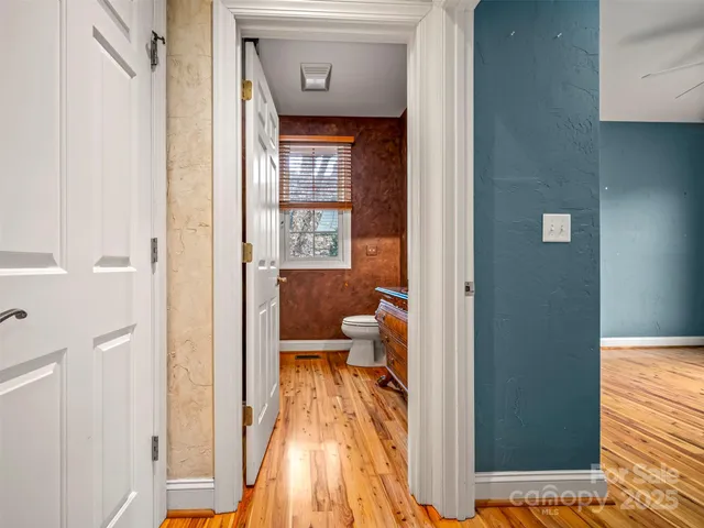 a view of a bedroom with a bed and wooden floor