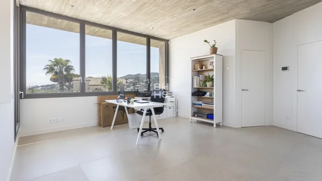 a view of a workspace with furniture and a window