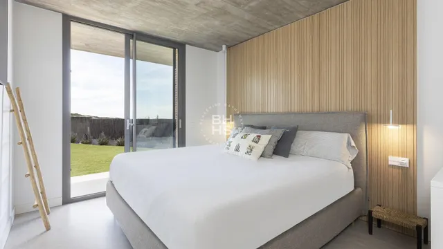 a large bed sitting in a bedroom next to a window