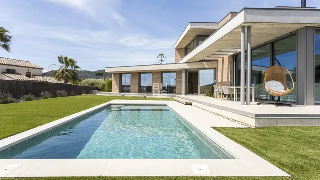a view of a house with a swimming pool and a yard