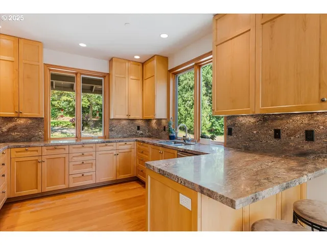a kitchen with stainless steel appliances granite countertop a sink a window and cabinets