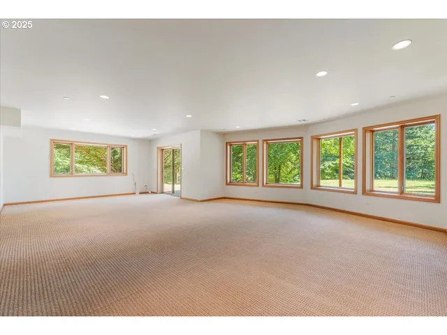 a view of an empty room with a fireplace and a window
