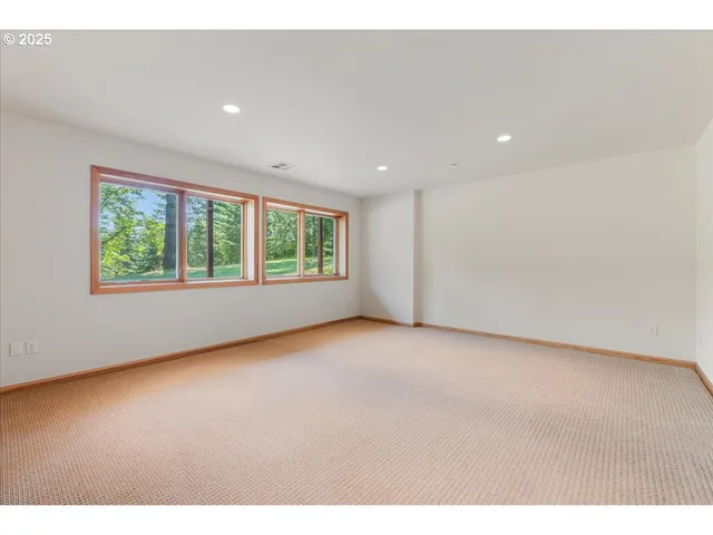 a view of a hallway with wooden floor and windows