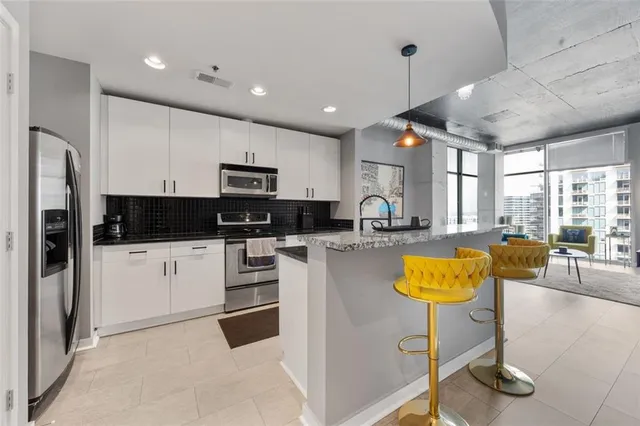 a kitchen with stainless steel appliances granite countertop a stove a sink a refrigerator and cabinets