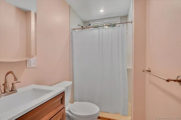 a bathroom with a sink a toilet and shower