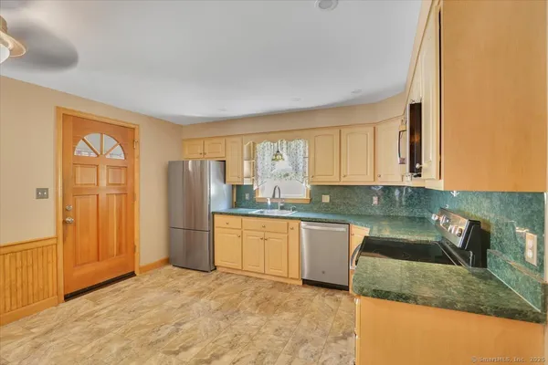 a kitchen with stainless steel appliances granite countertop a sink and a granite counter tops with white cabinets