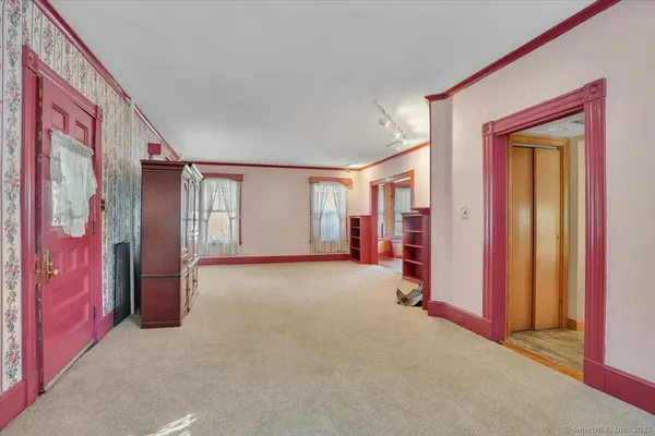 a view of an empty room with window and closet