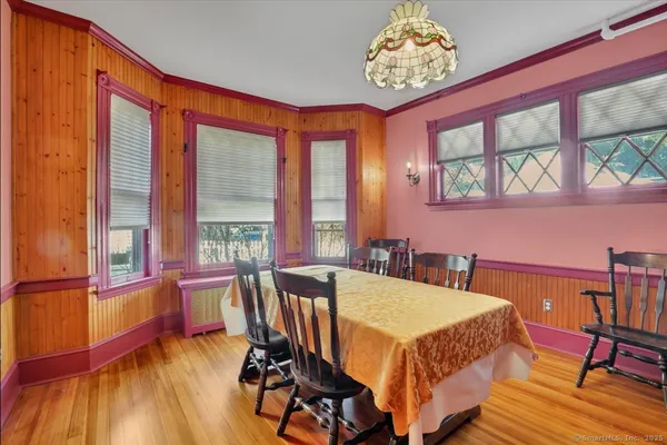 a view of a dining room with furniture a chandelier and wooden floor